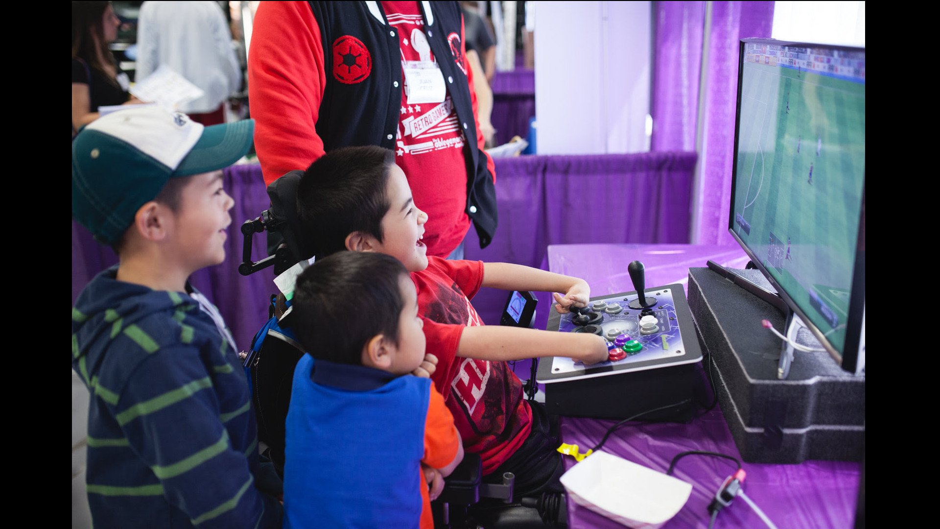 Kids gathered around specialized game controlled laughing and playing video games